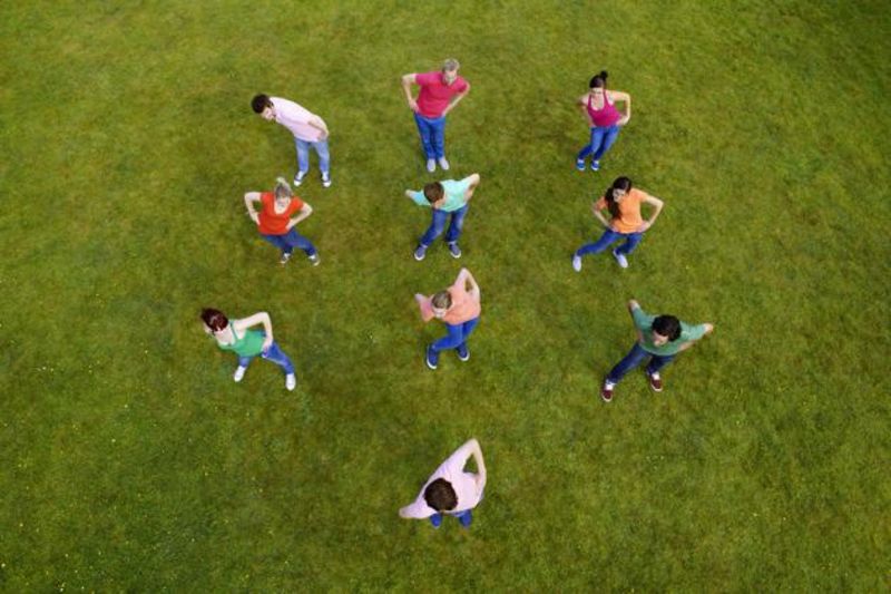 Abbildung: SchülerInnen, die auf einem Rasen Aufwärmübungen machen