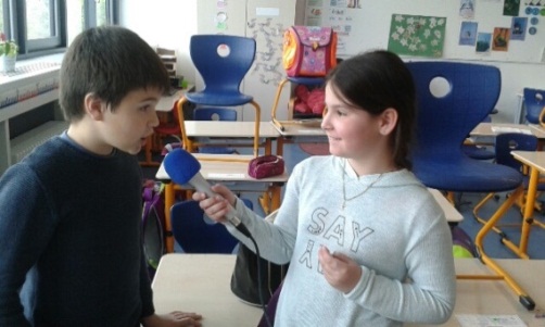 Abbildung zeigt eine Schülerin, die einen anderen Schüler im Rahmen der AG Schulradio interviewt.